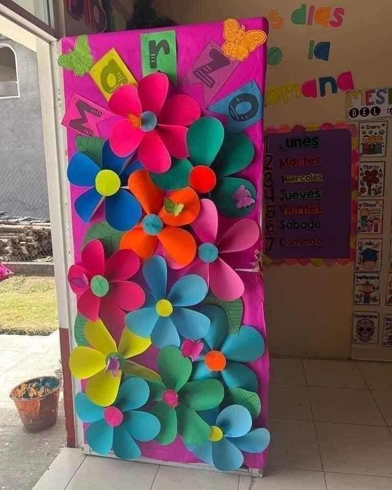 Vibrant spring classroom door with large, oversized paper flowers in bright rainbow colors.