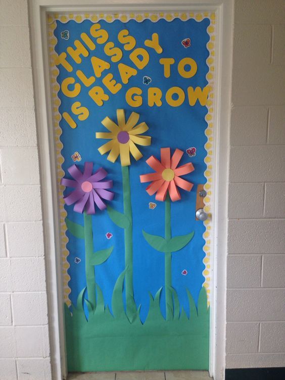 Simple and bold spring classroom door with large colorful flowers and the phrase 'This Class is Ready to Grow'.