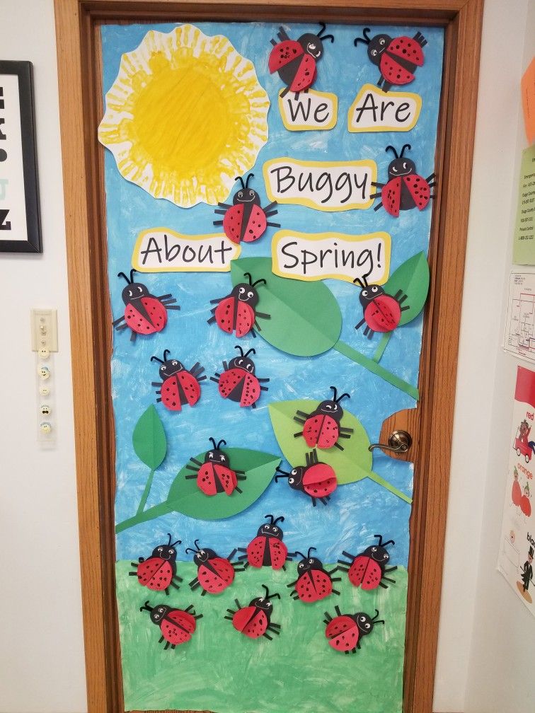 Spring classroom door featuring ladybugs, bright flowers, and the phrase 'We Are Buggy About Spring'.