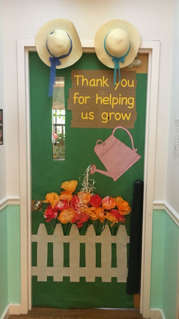Teacher appreciation spring classroom door with paper flowers, a picket fence, and a watering can.