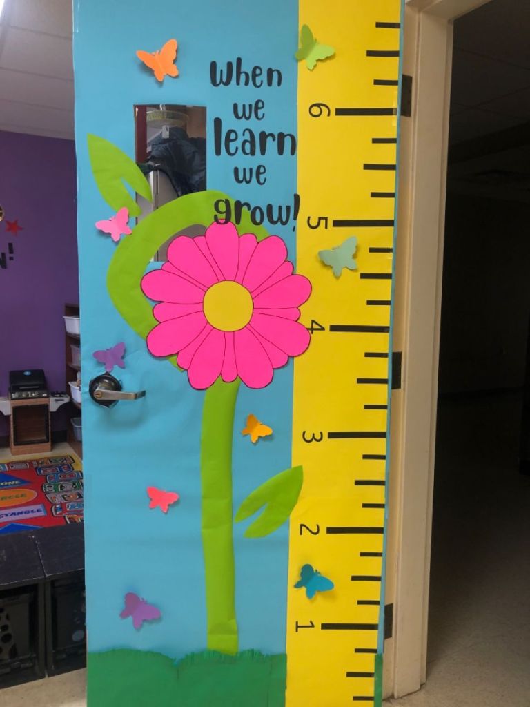 Educational growth-themed classroom door with a ruler and giant flower representing student progress.