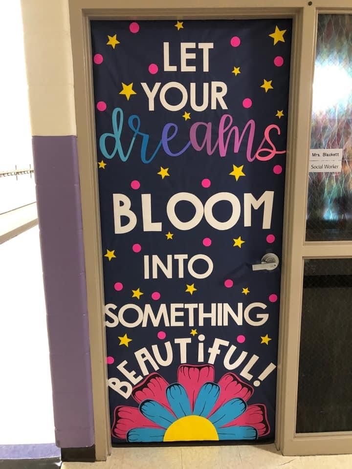 Motivational classroom door with the phrase 'Let Your Dreams Bloom Into Something Beautiful' and colorful typography.