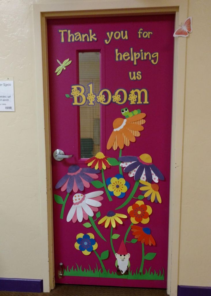 Teacher appreciation classroom door with a caterpillar, bright 3D flowers, and the phrase 'Thank You for Helping Us Bloom'.