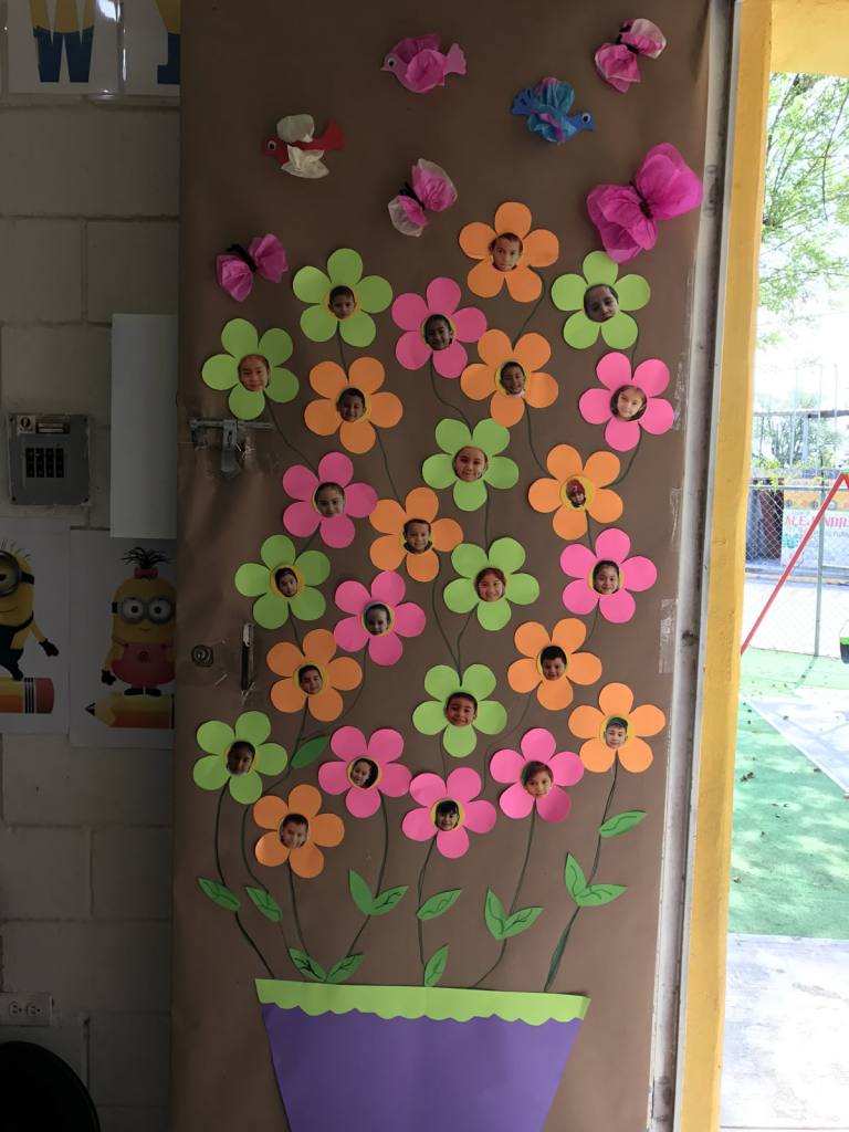 Personalized classroom door featuring a potted plant with flowers displaying students' photos in the centers.