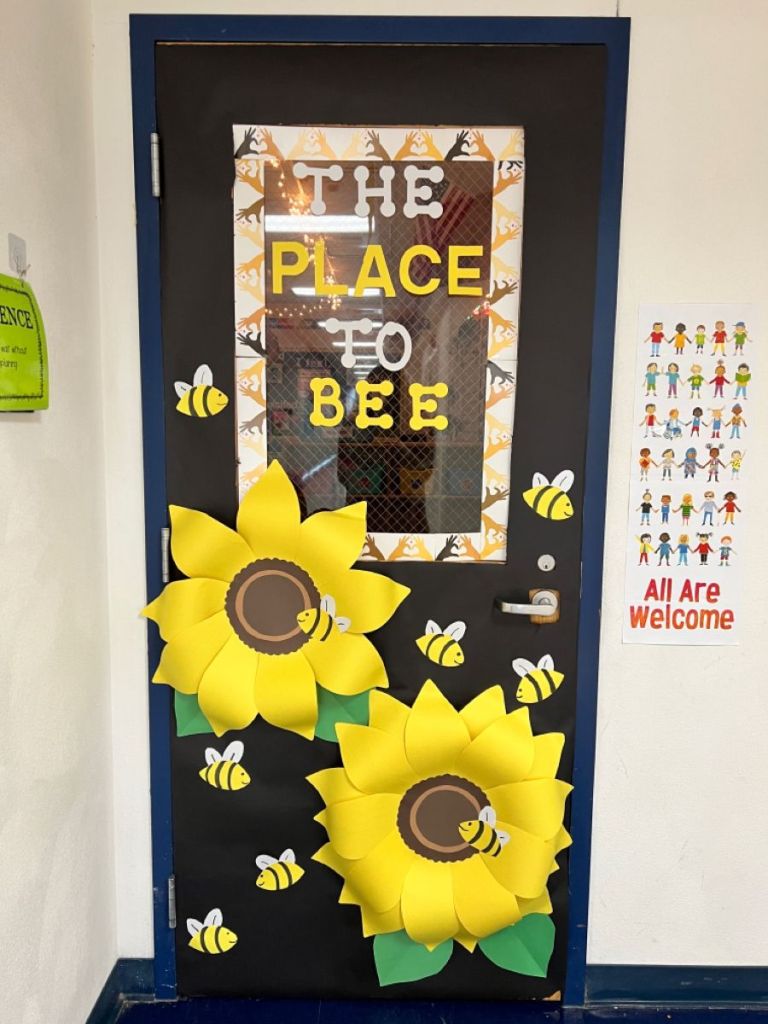 Sunflower and bee-themed spring classroom door with the phrase 'The Place to Bee'.
