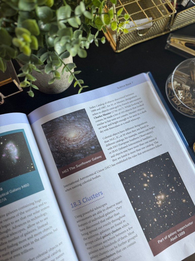An open page from a science textbook featuring information about galaxies, including M63 The Sunflower Galaxy and a section on clusters. The page includes illustrations of various celestial bodies and text explaining their characteristics.