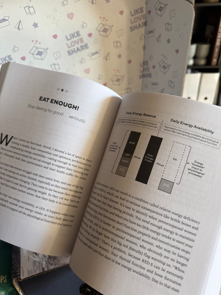 Open book page discussing nutritional advice for women, with highlighted text urging readers to eat enough and manage energy balance, set against a patterned background.