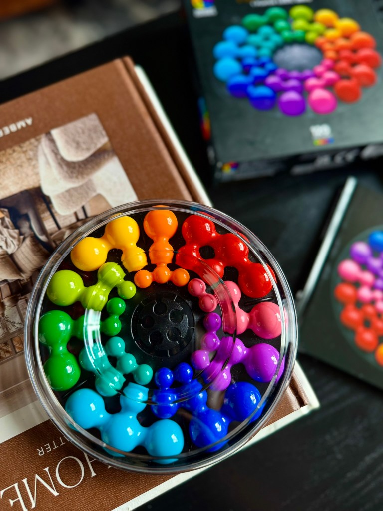 SmartGames IQ Circle logic game box displayed on a coffee table with colorful puzzle pieces
