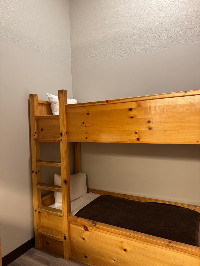 A wooden bunk bed setup in a KidKamp Suite at Great Wolf Lodge, showcasing a cozy and inviting space for kids.