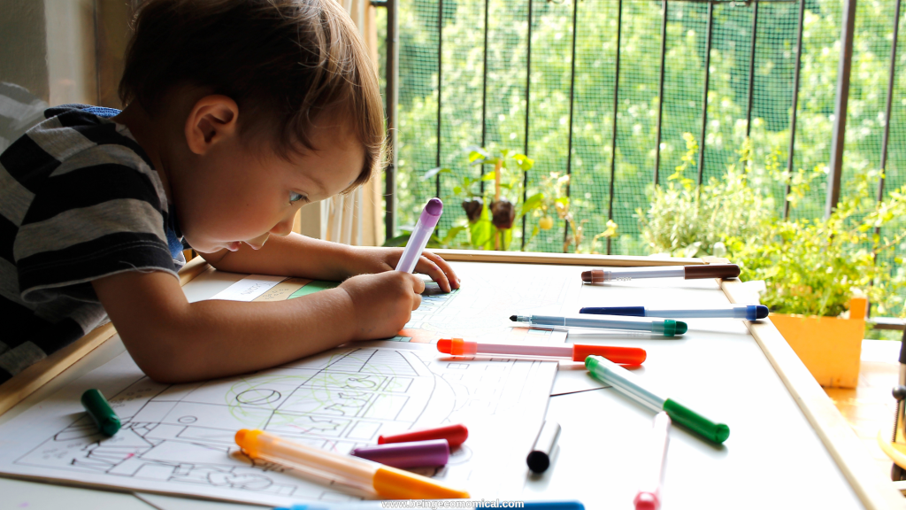 Preschooler practicing drawing and pre-writing skills at a table during homeschool preschool.