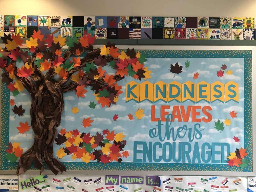 Kindness Leaves Others Encouraged fall bulletin board with a dimensional autumn tree and colorful falling leaves.