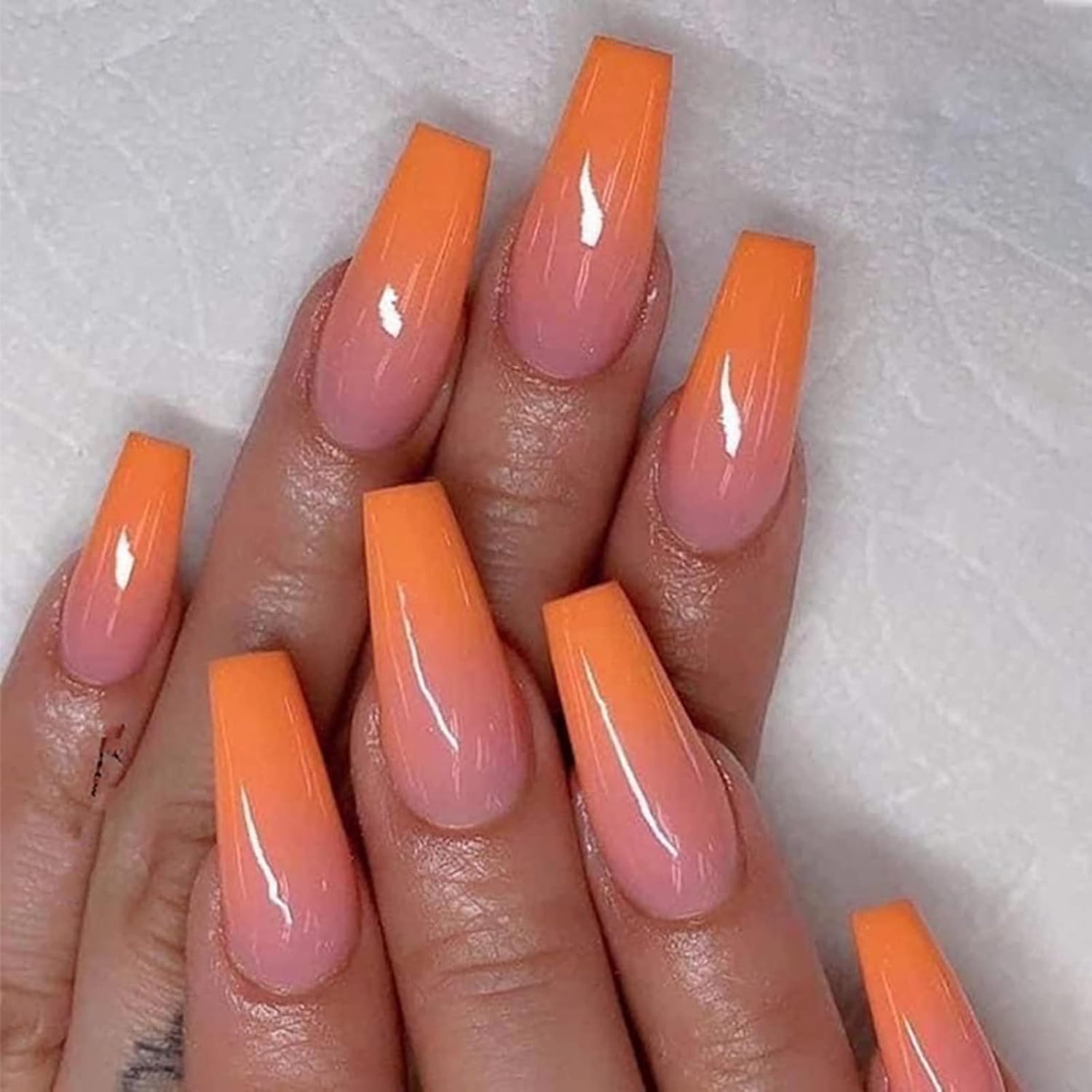 Long coffin nails with soft orange ombre gradient and glossy top coat