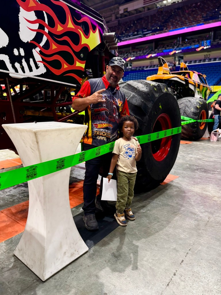 Young child poses with the Bone Shaker driver during the Hot Wheels preshow.