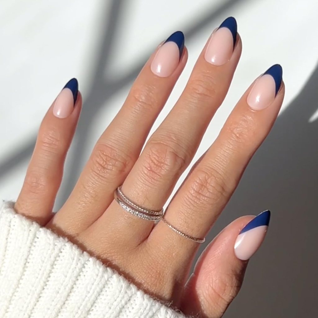 Classic navy blue French tip almond nails with glossy nude base and dark blue tip manicure.