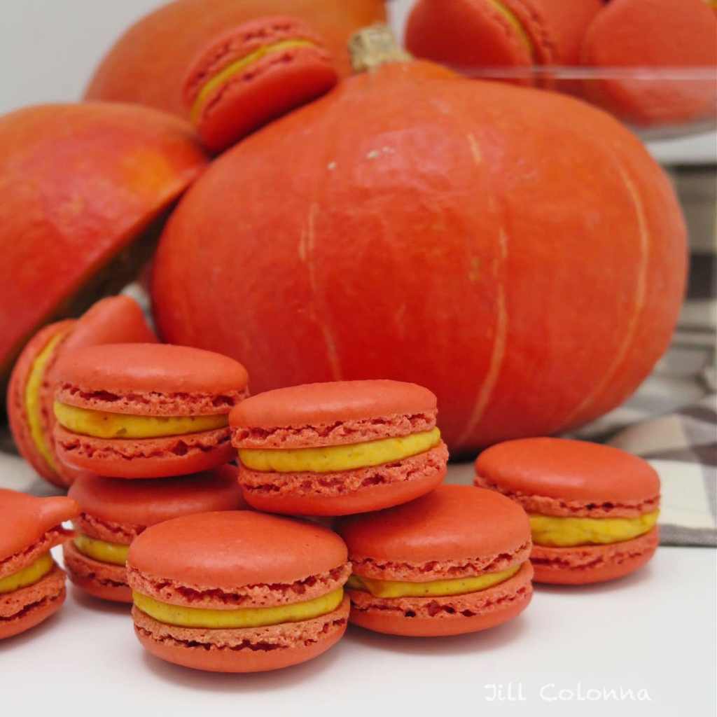 Homemade pumpkin spice macaroons stacked on a plate – cozy pumpkin dessert idea.