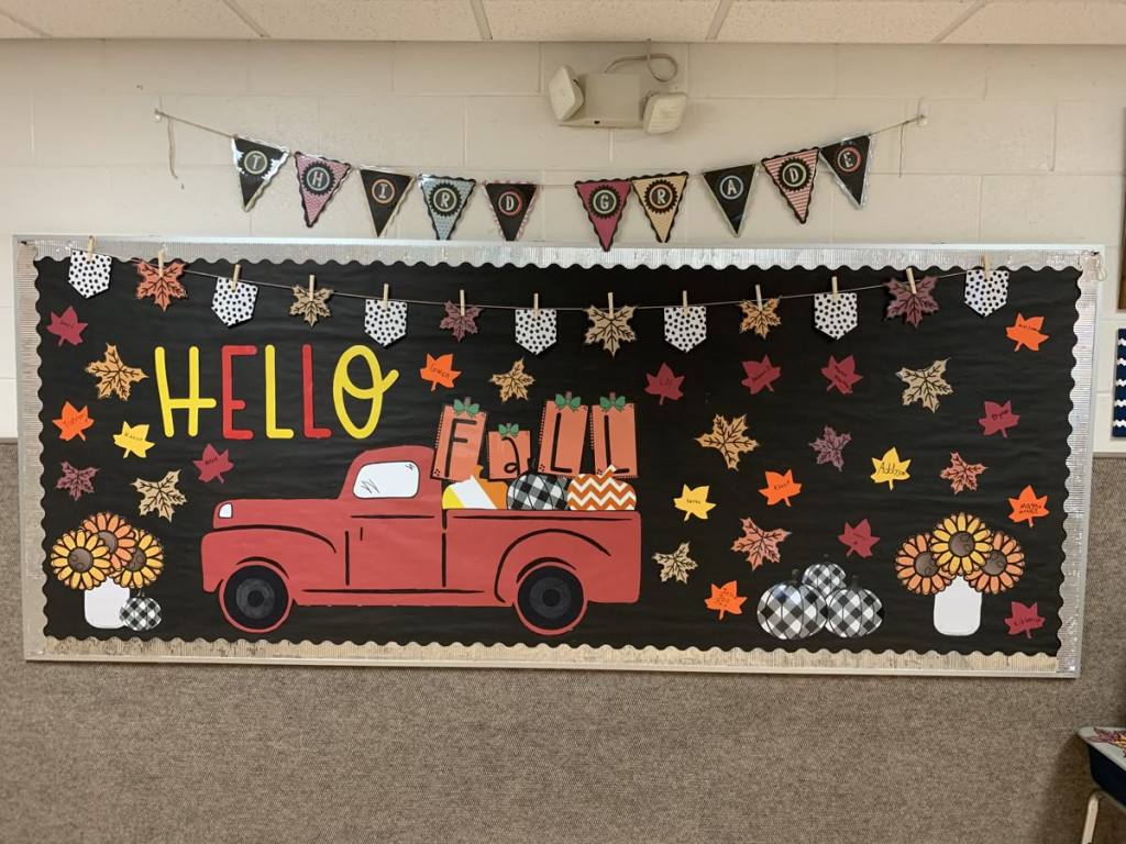 Hello Fall bulletin board featuring a red vintage truck filled with pumpkins, colorful leaves, sunflowers and fall decorations.