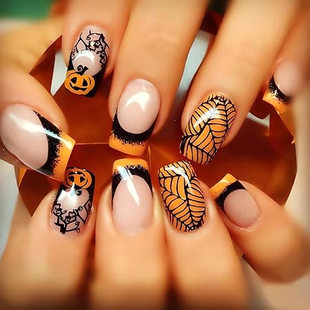 Halloween-themed nails featuring pumpkins and intricate leaf designs with a black and orange color scheme.