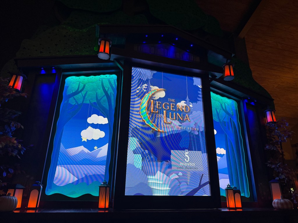 A brightly lit indoor display announcing 'The Legend of Luna', a Great Wolf Lodge story, with colorful animated graphics and decorative lanterns nearby.