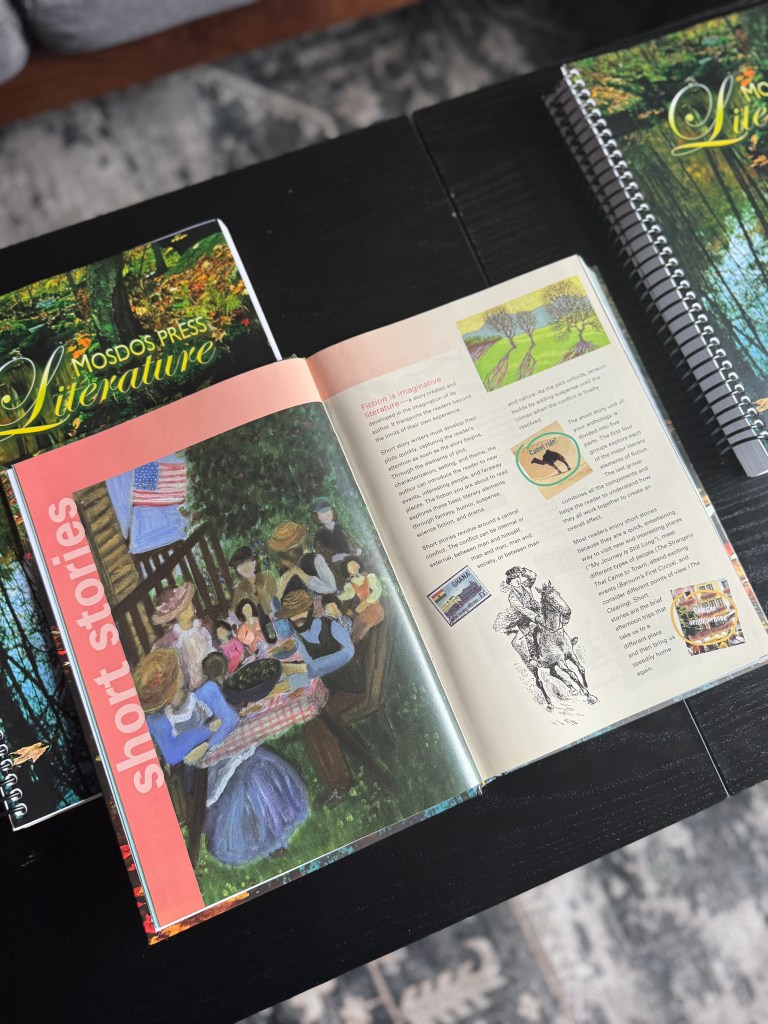 An open book featuring vibrant illustrations and text from the Mosdos Press Literature curriculum, with a picnic scene and children gathered around a table enjoying a meal.