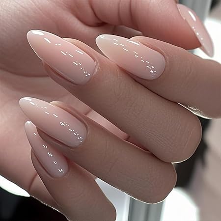A close-up of elegantly manicured almond-shaped nails featuring a soft milky nude finish with a glossy shine.