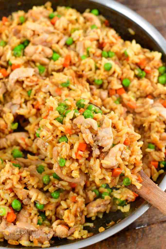 Chicken fried rice with vegetables and eggs cooked in a skillet for a fast takeout-style meal