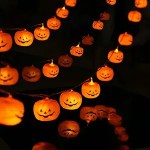 A string of glowing jack-o'-lantern lights in a dark setting, creating a festive Halloween atmosphere.