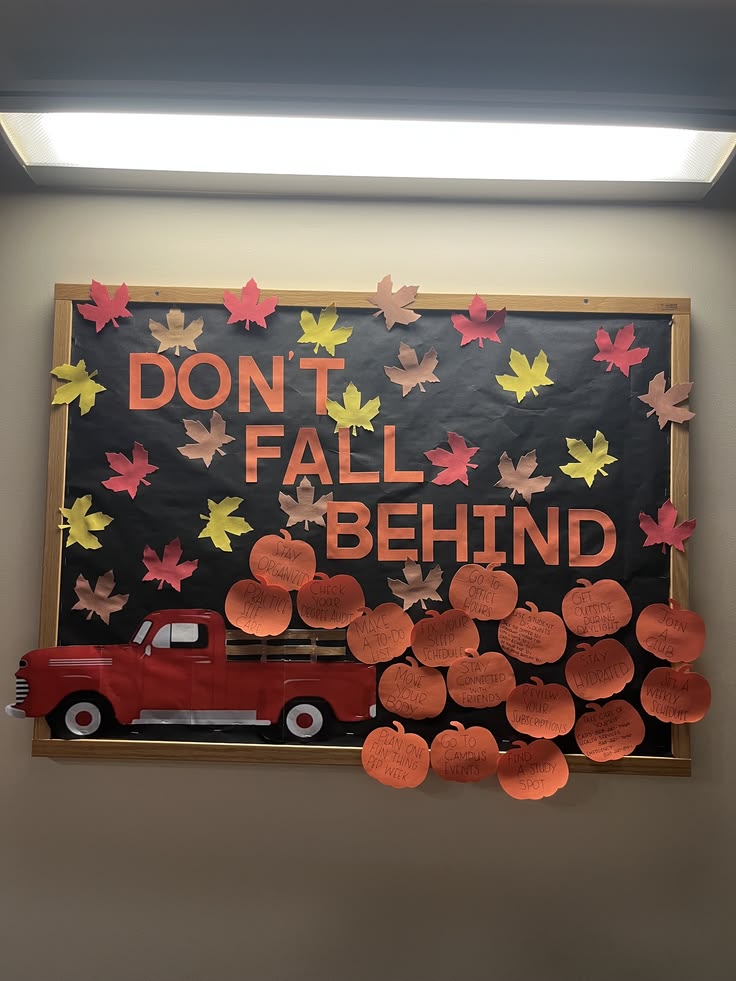 Don't Fall Behind fall bulletin board featuring a red vintage truck, paper pumpkins and colorful falling autumn leaves.