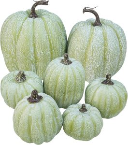 A collection of greenish-white pumpkins in various sizes, showcasing textured surfaces and bulbous shapes, perfect for fall decor.