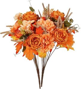 A bouquet of artificial flowers in warm autumn tones, featuring orange roses, golden leaves, and decorative accents, perfect for adding seasonal charm to a Thanksgiving tablescape.