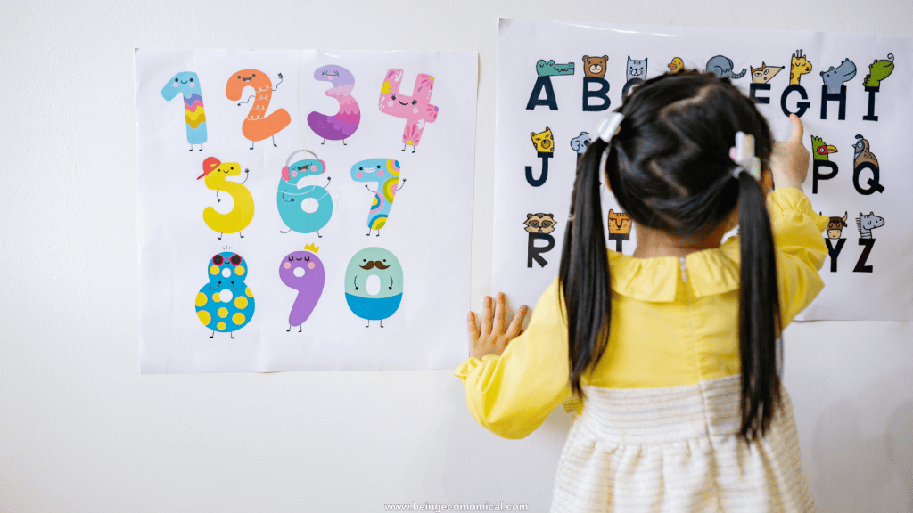3 year old learning activities with a child practicing letters and numbers using educational wall posters