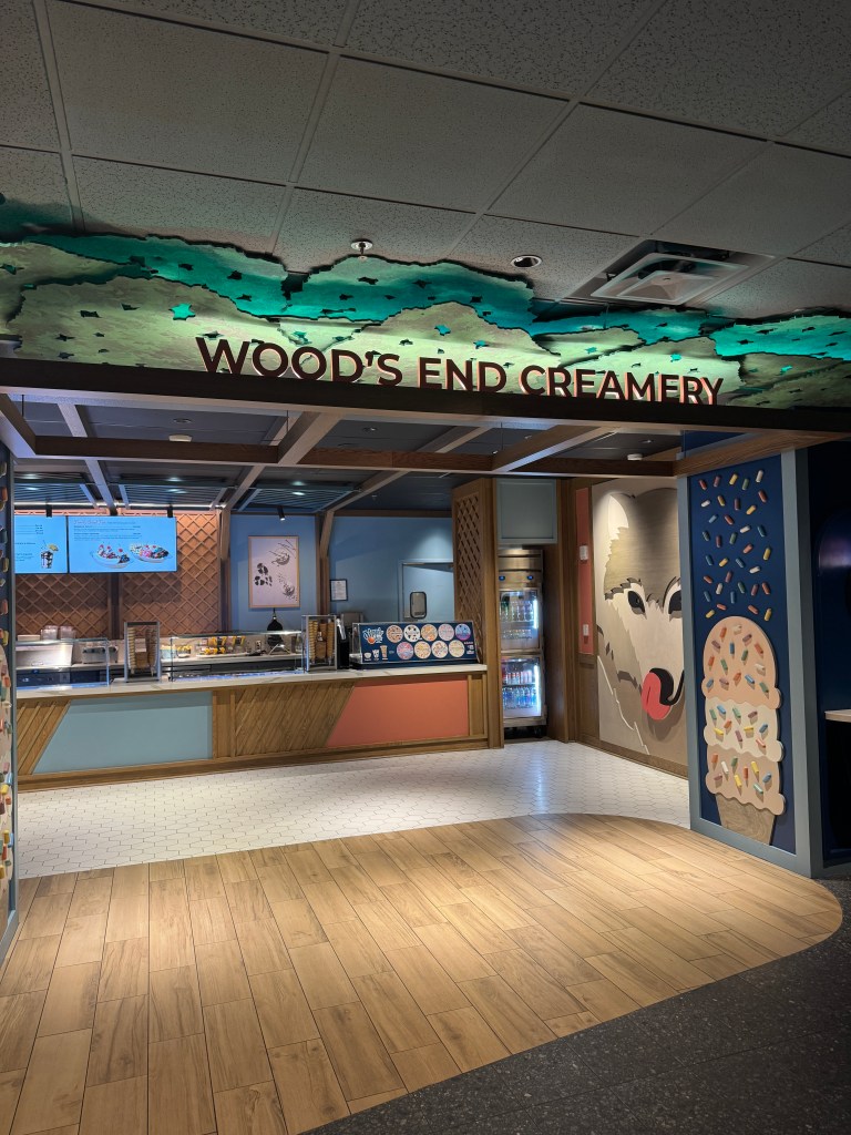 Entrance to Wood's End Creamery featuring a vibrant sign and colorful decor. Ice cream shop at Great Wolf Lodge in Grapevine, TX.