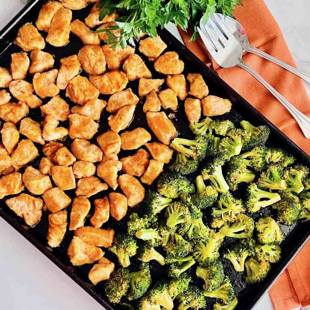 Sheet pan buffalo chicken and roasted broccoli tossed in a spicy sauce