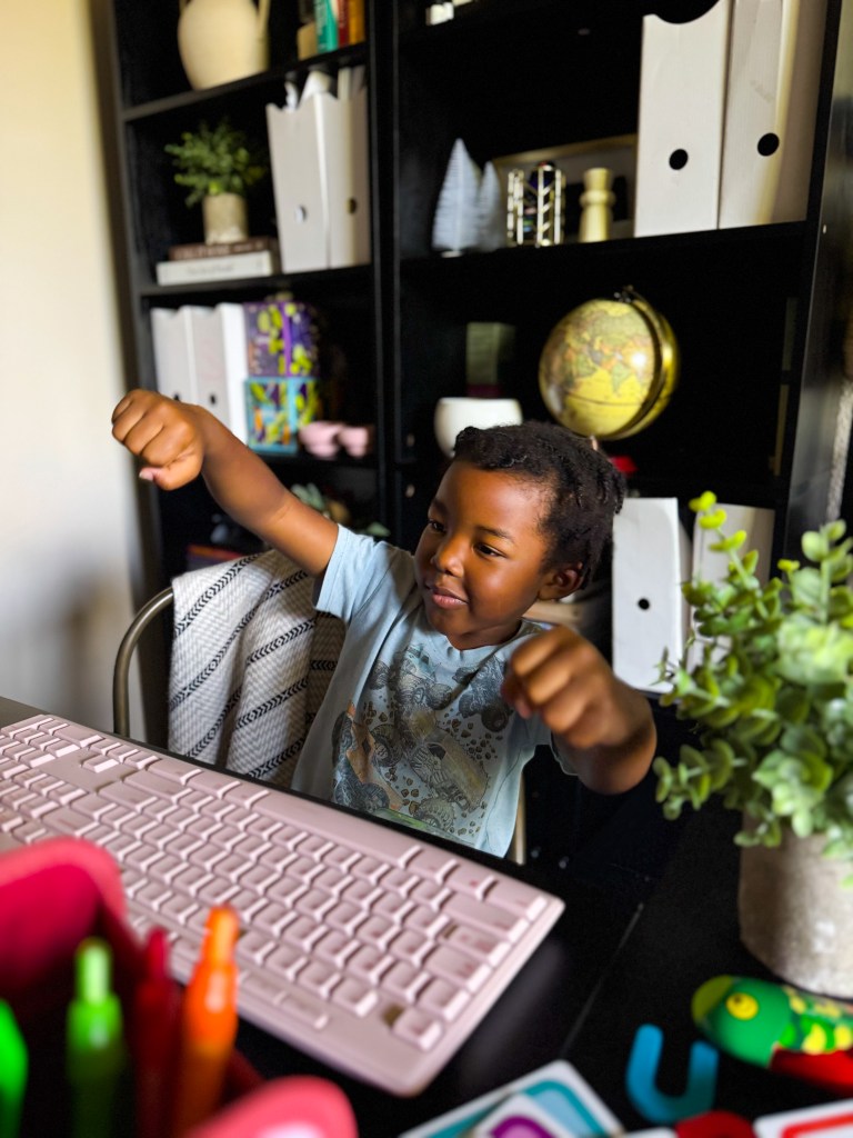 Child acting out a movement prompt during a kindergarten phonics homeschool activity