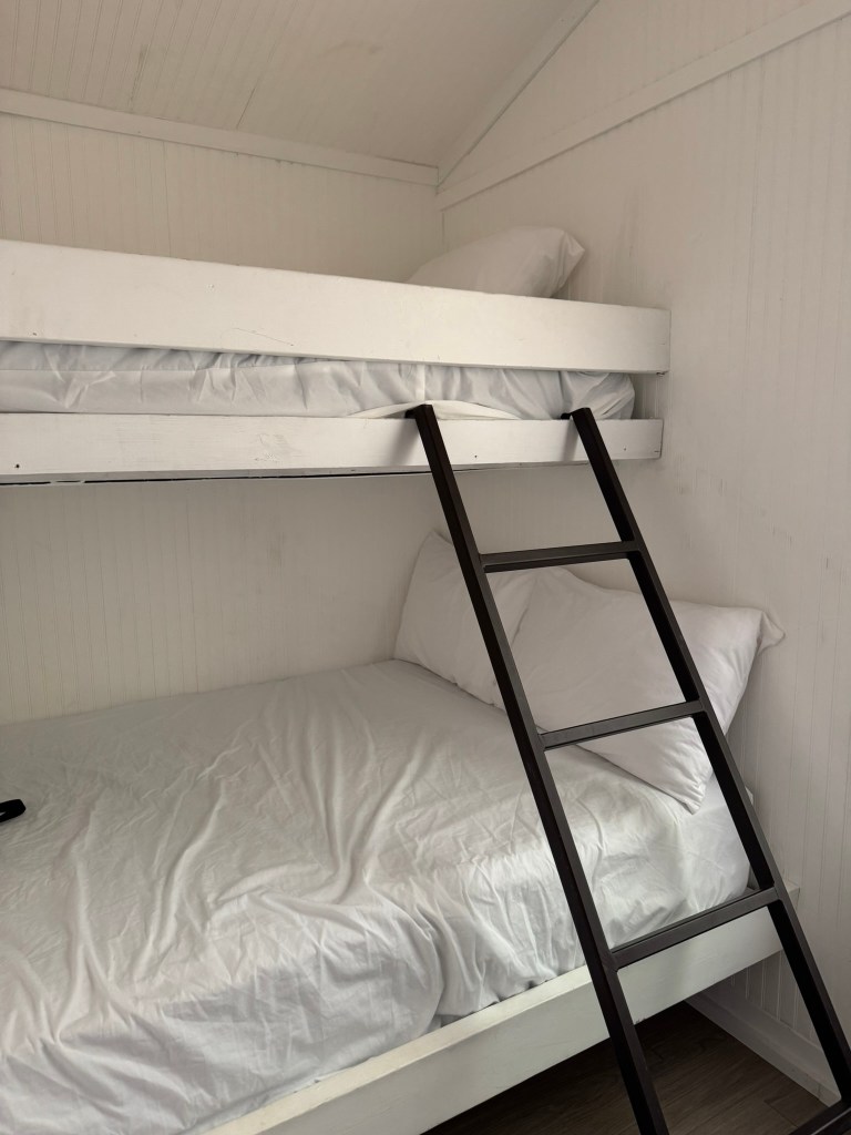 White bunk beds with black ladder inside a Jellystone Park Pigeon Forge cabin