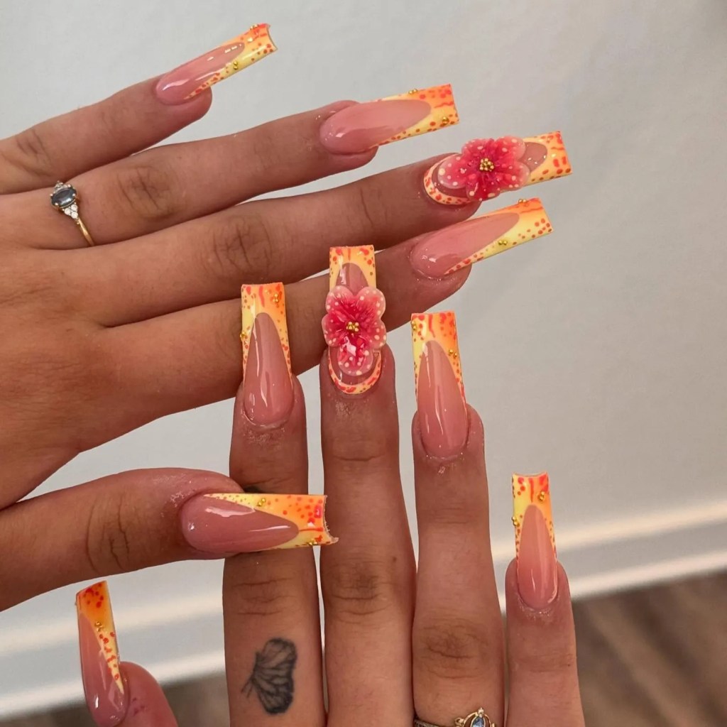 Nude almond nails with orange French tips and raised 3D flower design