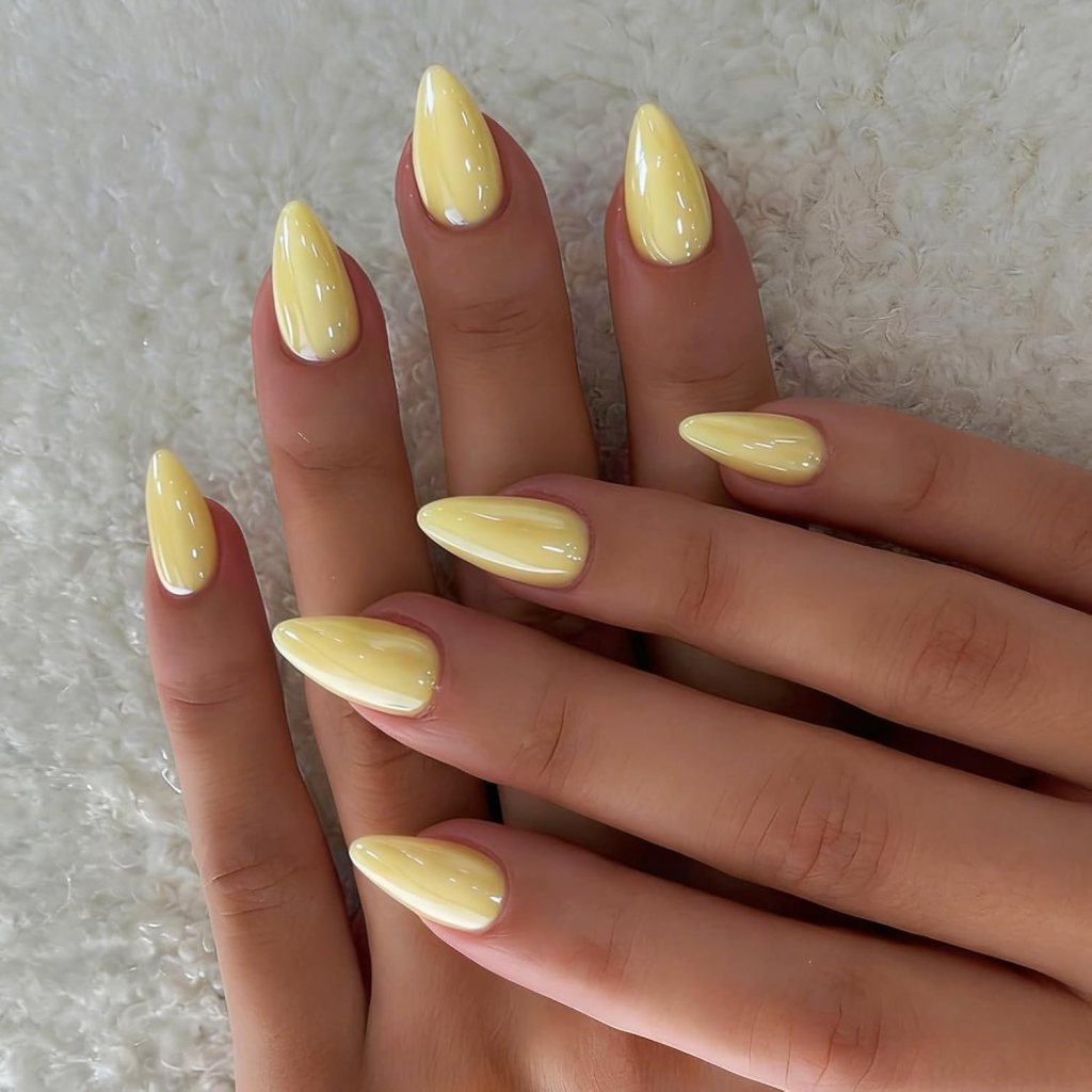 Simple glossy butter yellow almond nails with soft pastel polish and clean minimalist manicure aesthetic