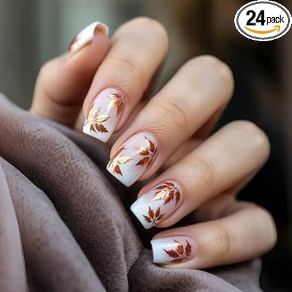 Elegant nails featuring a gradient design with white tips and copper-toned leaf accents, showcasing a cozy fall aesthetic.