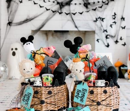Two woven baskets filled with colorful Halloween treats, plush toys, and themed decorations, set against a backdrop of spooky decorations.
