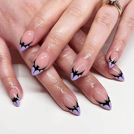 Almond-shaped nails featuring a pastel lavender base with black bat tips, giving a spooky yet stylish Halloween vibe.