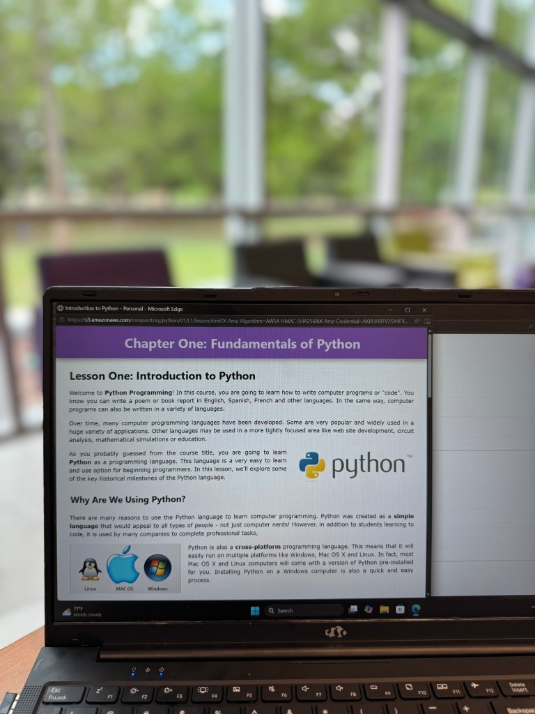 Introduction to Python lesson from CompuScholar displayed on laptop for beginner coding students