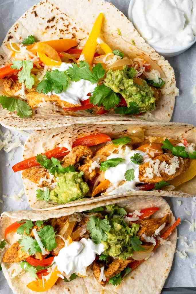 Chicken fajita tacos with peppers and onions served in warm tortillas
