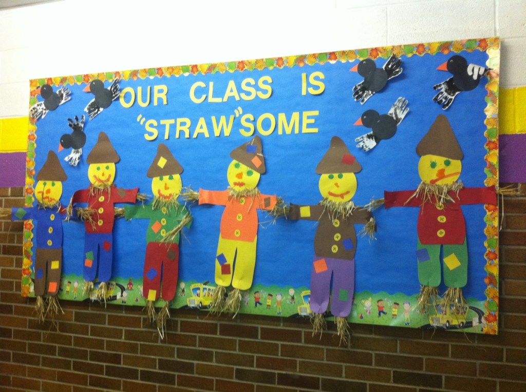 Scarecrow fall bulletin board featuring colorful student-made scarecrows, crows and Our Class Is Straw-Some lettering.