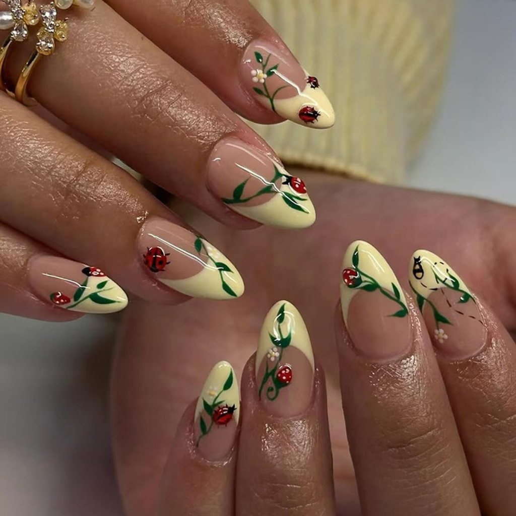Butter yellow ladybug floral nails with cute nature inspired nail art and glossy almond manicure design