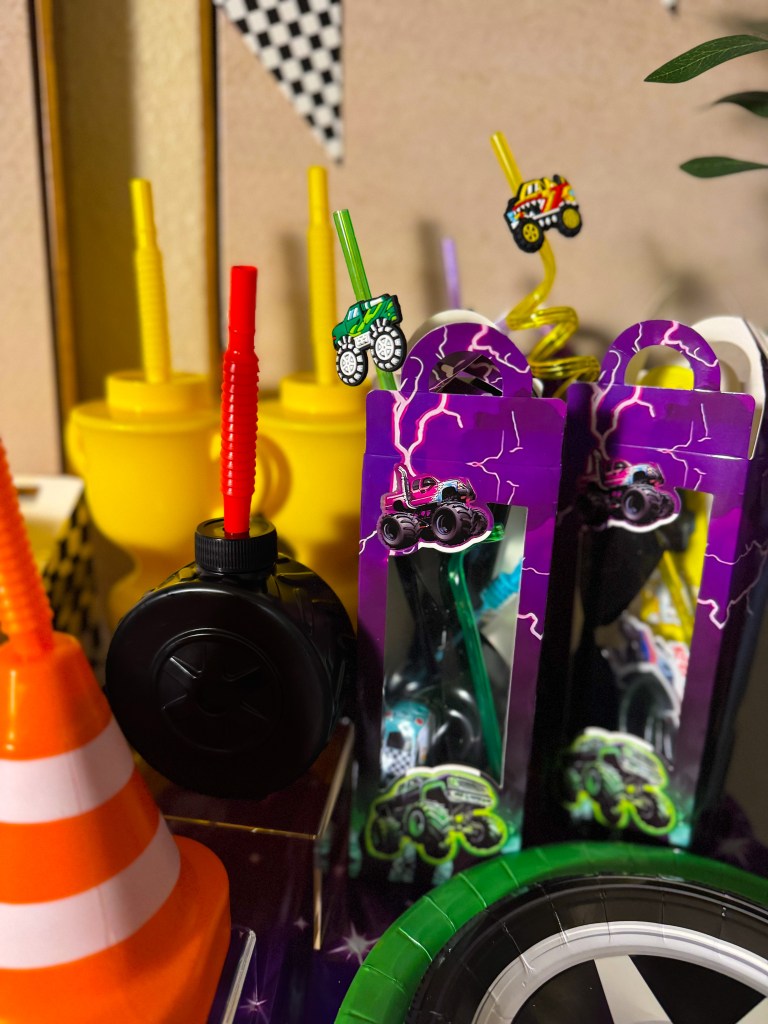 Monster Jam birthday party snacks and favors with monster truck themed treat boxes, racing decorations, and party drinks.