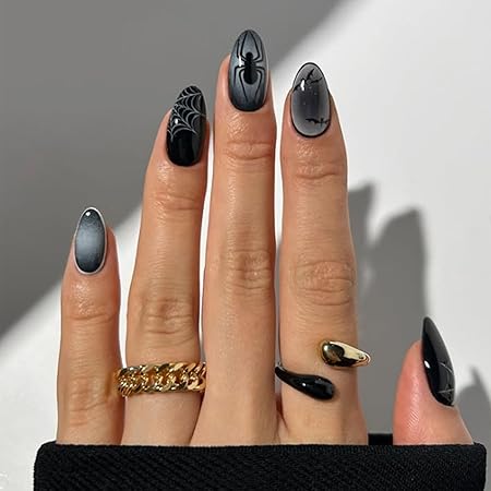 Black nails featuring intricate spider and web designs, accented with glossy finishes and chic rings.