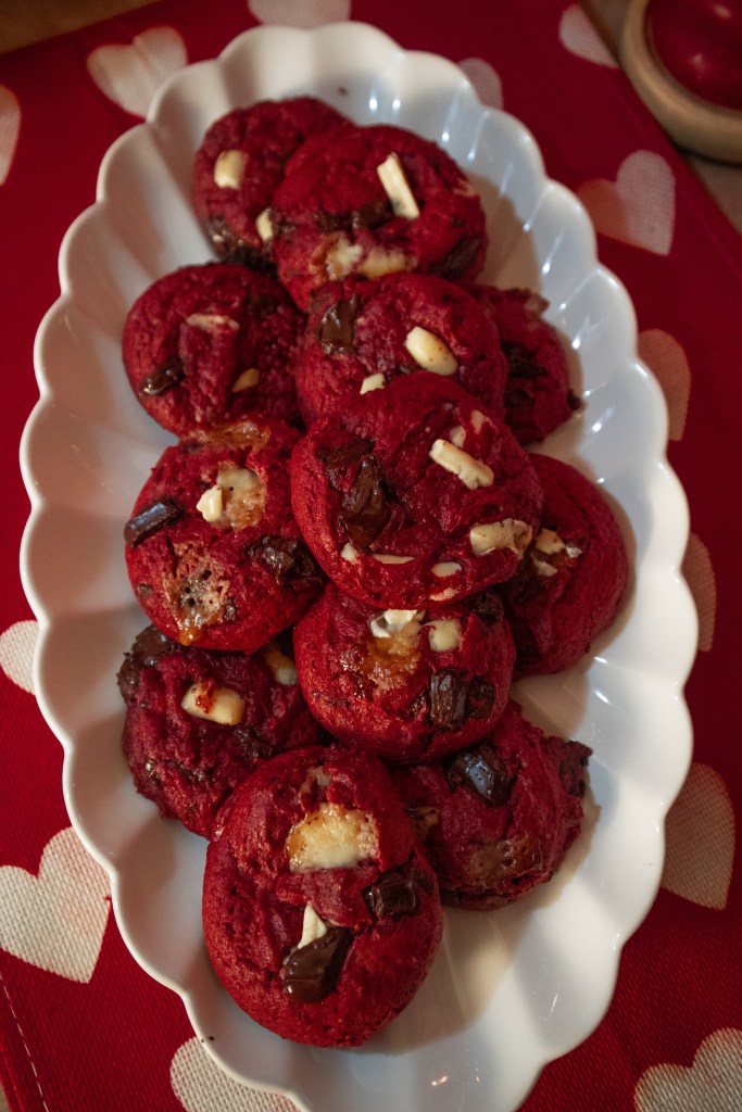A platter of red velvet cookies with chocolate chips and white chocolate chunks, arranged beautifully.