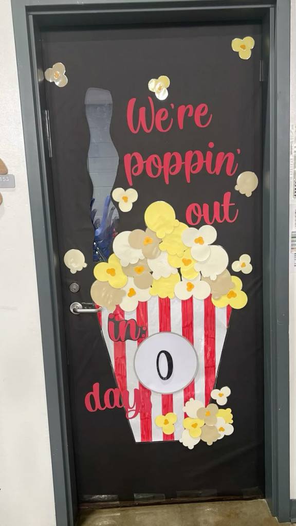 End of year classroom door idea with popcorn theme reading “We’re poppin’ out” with popcorn decorations and countdown display