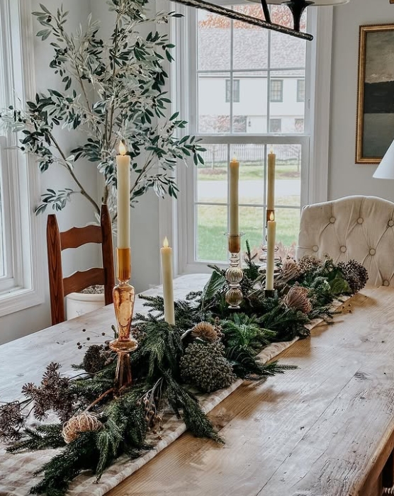 A beautifully styled Thanksgiving table with a centerpiece of greenery, candles, and natural elements, creating a warm and inviting atmosphere.