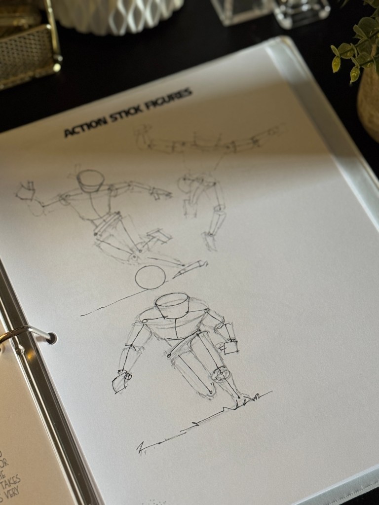 A close-up of a sketchbook page featuring sketches of action stick figures in various dynamic poses, illustrating movement and energy.