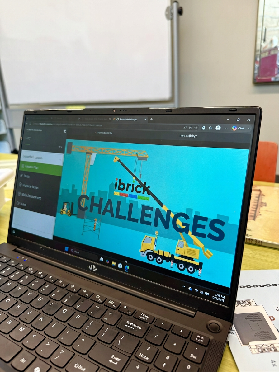 Laptop screen showing a digital learning activity titled 'ibrick CHALLENGES' with construction crane graphics